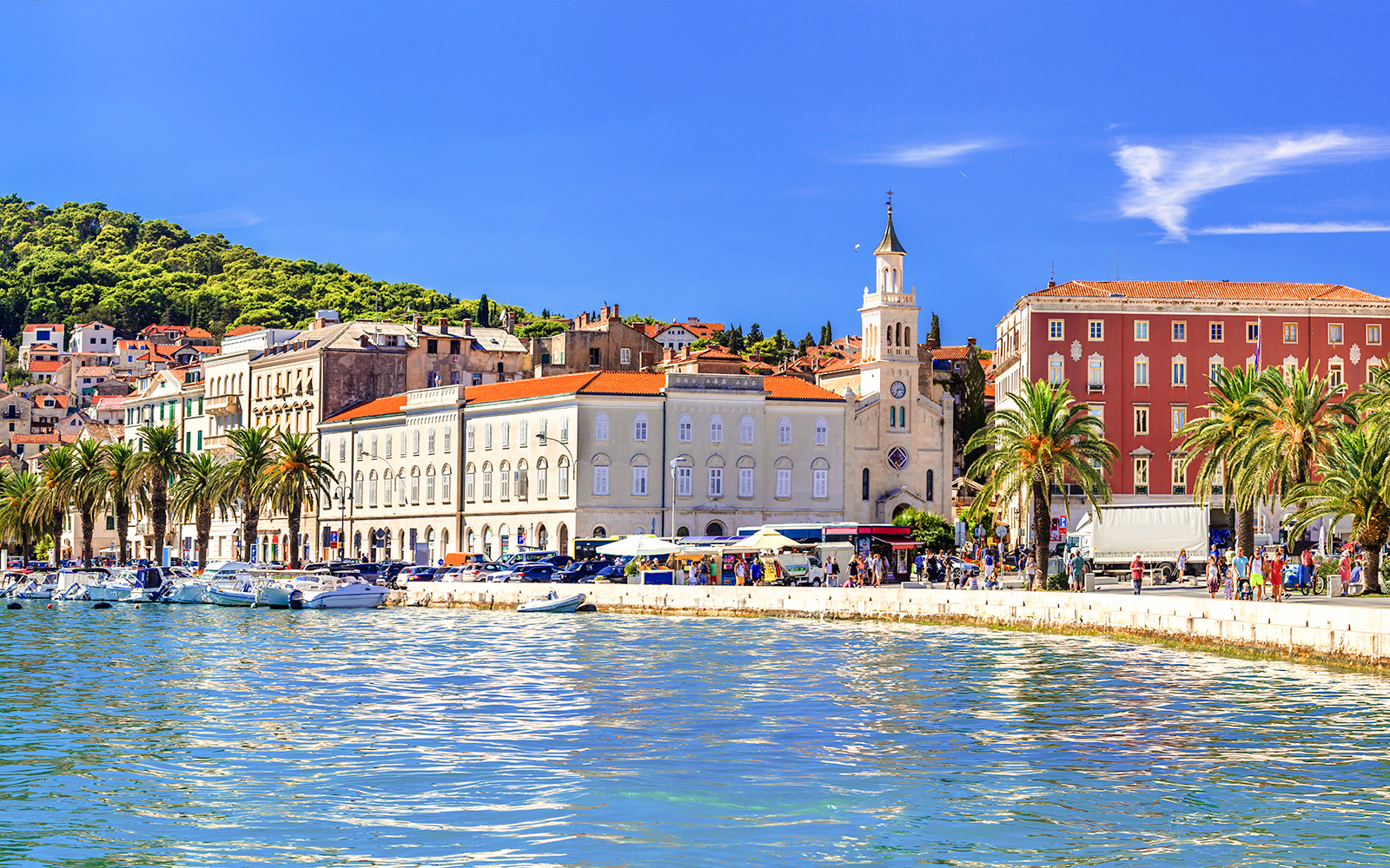 Riva promenade in Split, Croatia with waterfront, palm trees, and historic buildings.
