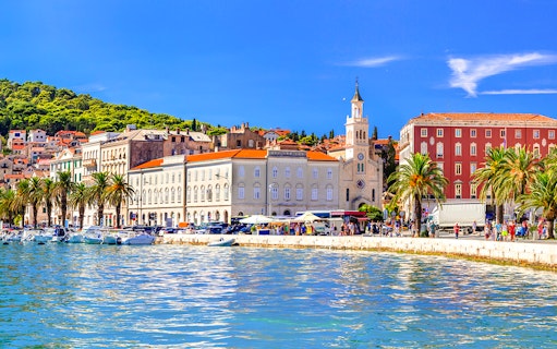Riva promenade in Split, Croatia with waterfront, palm trees, and historic buildings.