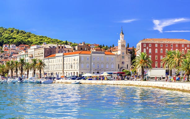Riva promenade in Split, Croatia with waterfront, palm trees, and historic buildings.