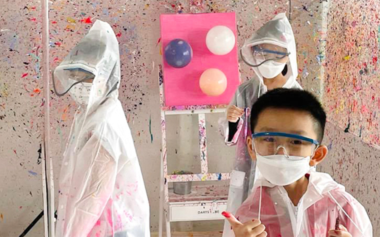 Young kids in protective gear at a Balloon Splatter Art Workshop.