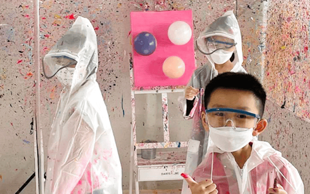 Young kids in protective gear at a Balloon Splatter Art Workshop.