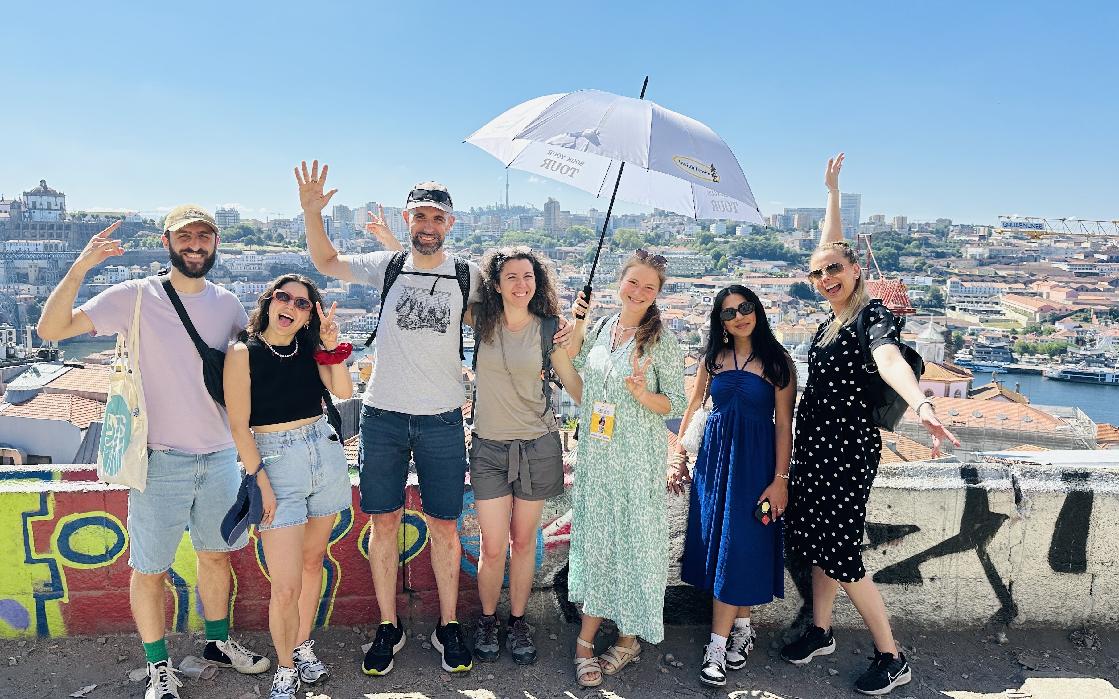 Tourists with guide overlooking Porto, Portugal cityscape.
