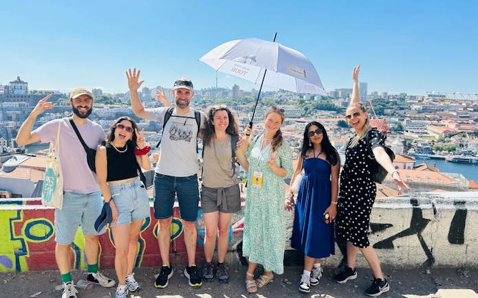 Tourists with guide overlooking Porto, Portugal cityscape.