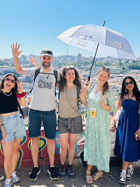 Tourists with guide overlooking Porto, Portugal cityscape.