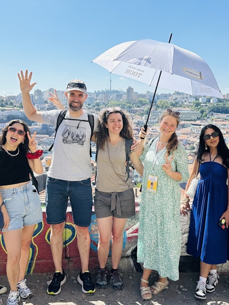Tourists with guide overlooking Porto, Portugal cityscape.