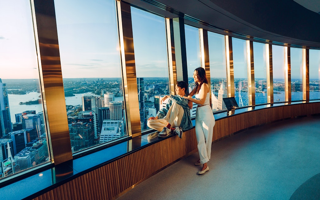 Couple enjoying city view from Sydney Tower Eye observation deck.