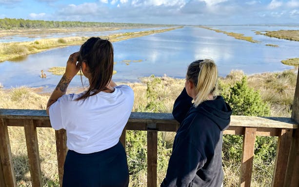 Two people observing Karavasta Lagoon from a watchtower, Albania.