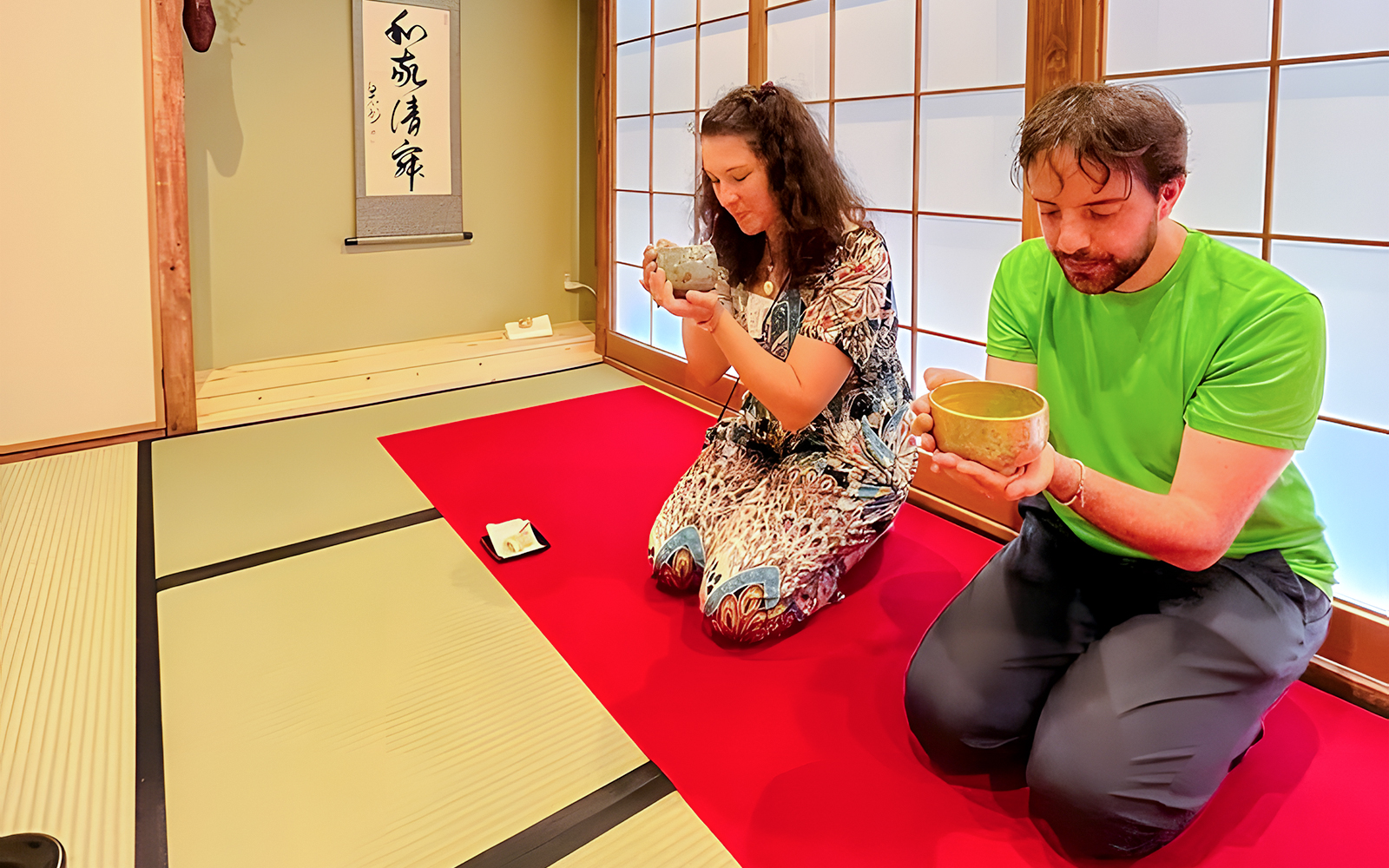 Couple enjoying matcha tea ceremony in traditional Japanese room, Osaka.