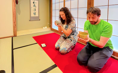 Couple enjoying matcha tea ceremony in traditional Japanese room, Osaka.