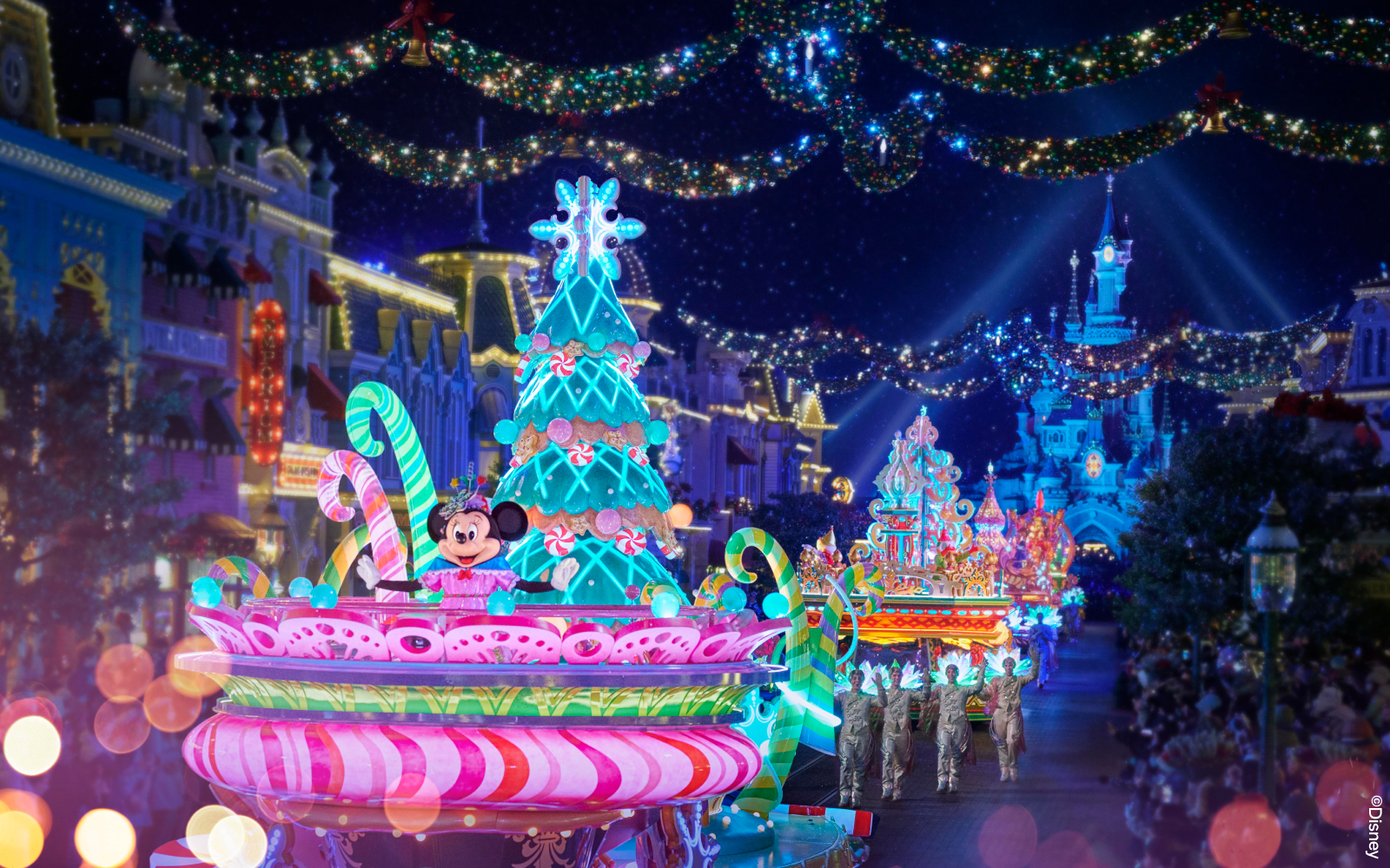 Disneyland Paris Electrical Parade with illuminated floats and characters at night.