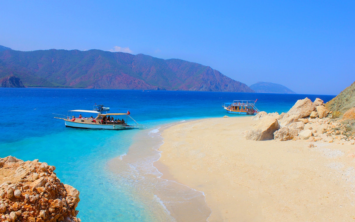 Boats anchored near Suluada Island's sandy beach, Antalya coast.