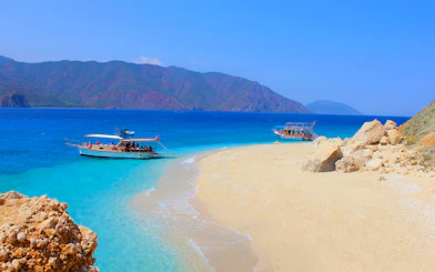 Boats anchored near Suluada Island's sandy beach, Antalya coast.
