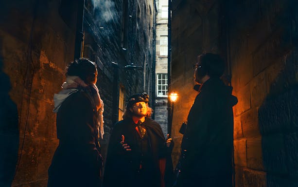 Guide narrating ghost stories to a group during a ghost tour in Edinburgh