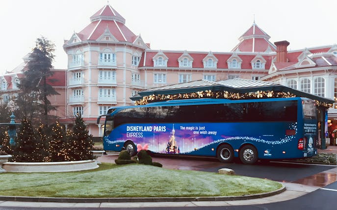 Disneyland Paris Express bus parked in front of a hotel, ready for round-trip to Paris.