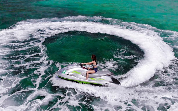 Jet skiing on Pattaya Island's turquoise waters during a day trip from Bangkok.