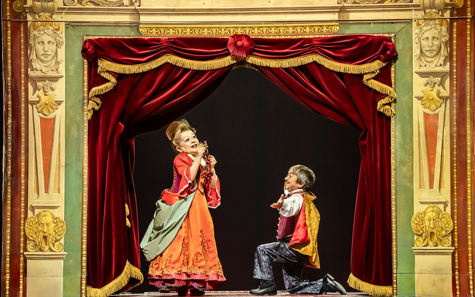 Cirque du Soleil performers in Corteo show with acrobats and aerialists in vibrant costumes.