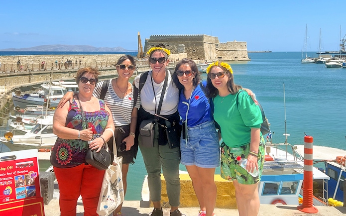 Group of tourists at Heraklion harbor with Venetian fortress in the background.