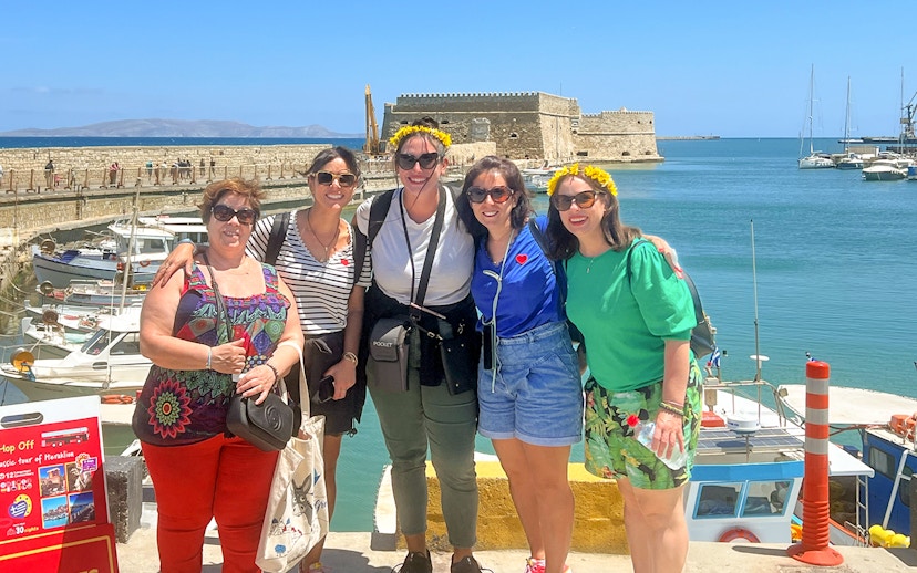 Group of tourists at Heraklion harbor with Venetian fortress in the background.