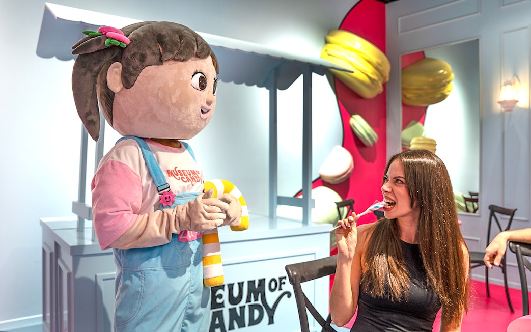 Visitor enjoying candy with cartoon character at Museum of Candy, Dubai.