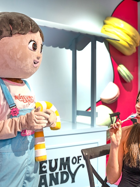 Visitor enjoying candy with cartoon character at Museum of Candy, Dubai.