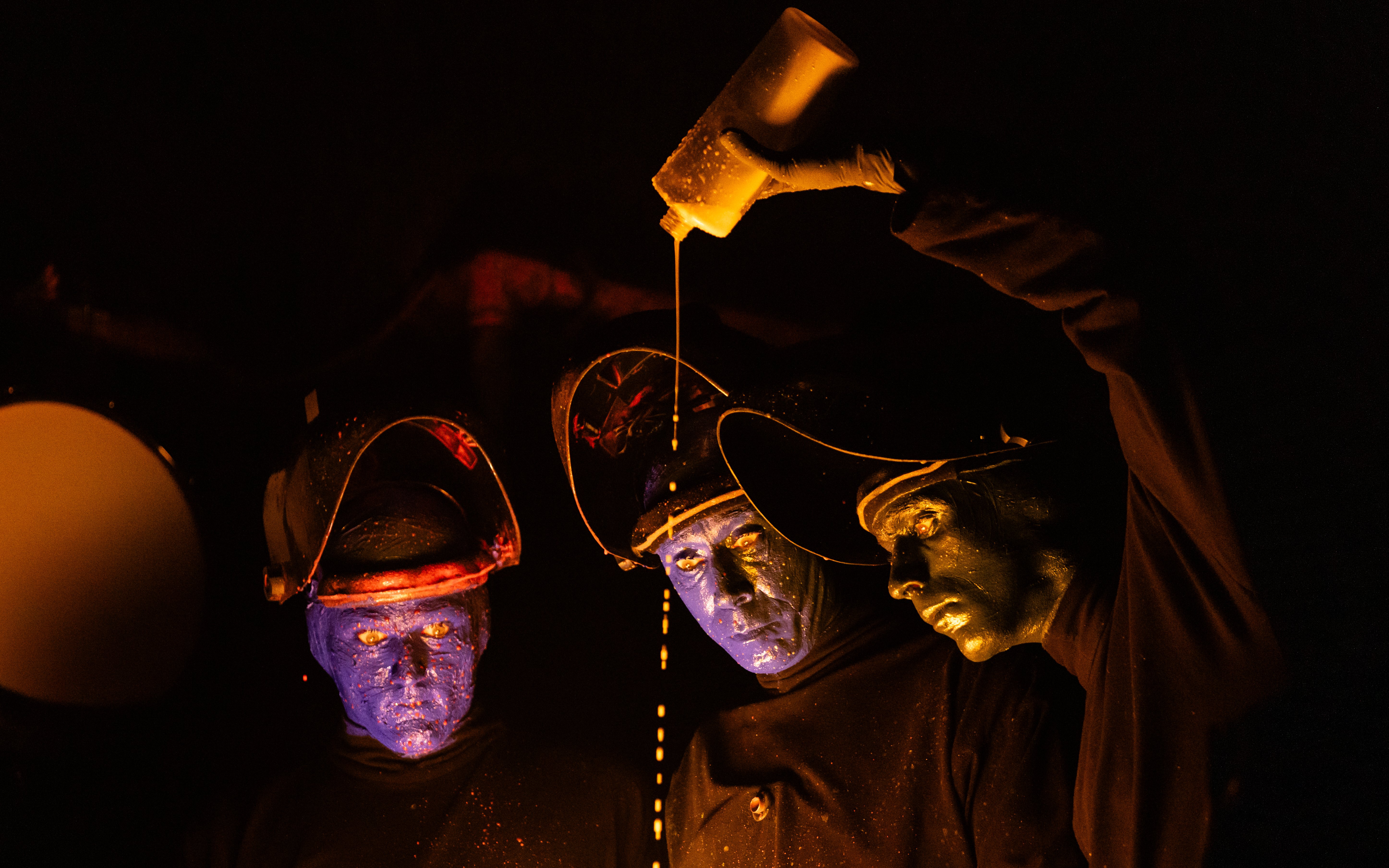 Blue Man Group performers on stage with glowing paint, Orlando.