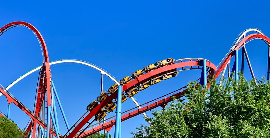Roller coaster at Land of the Dragons, Chessington World, with red tracks and blue sky.