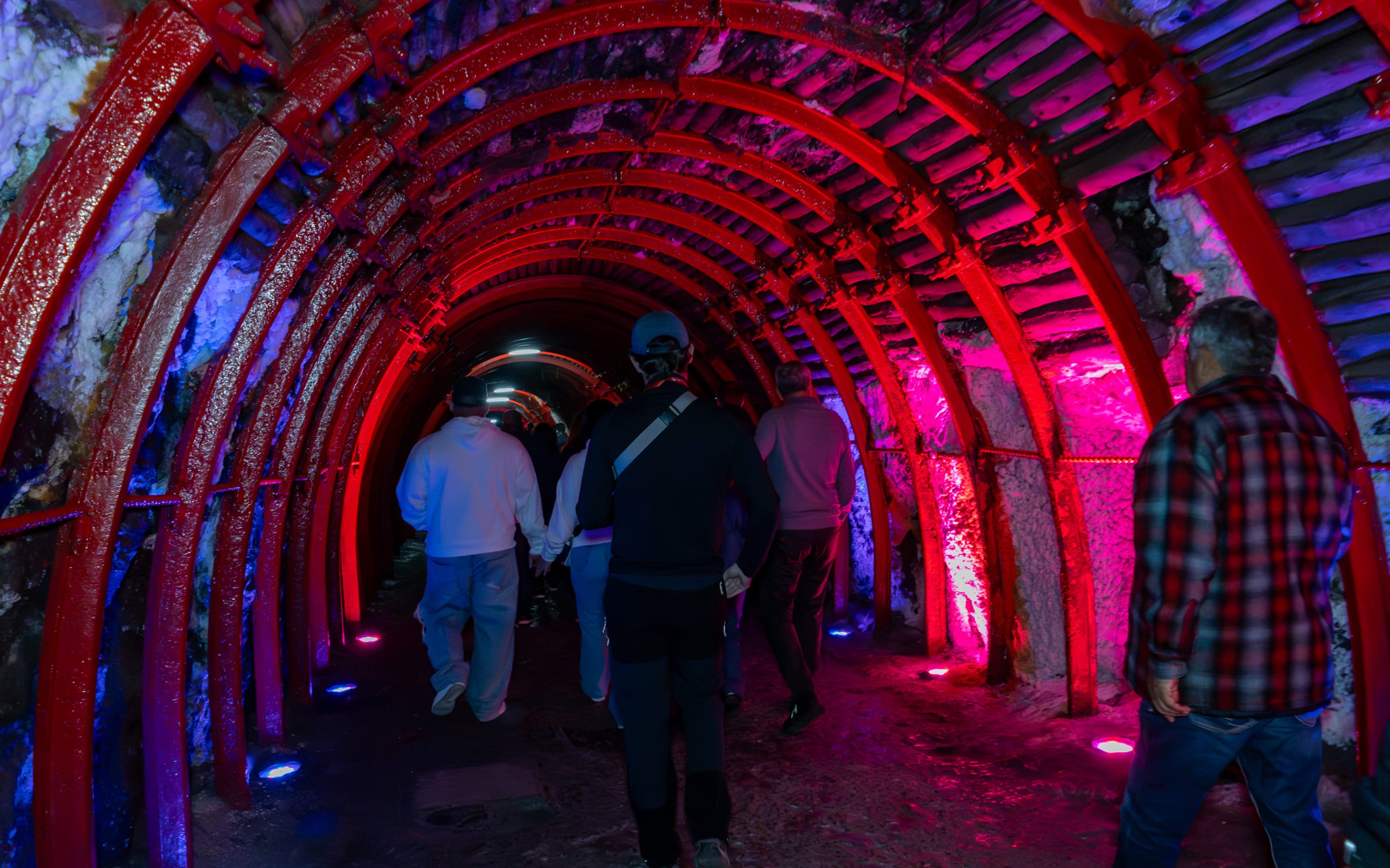 Tourists walking through illuminated tunnel to Zipaquira Salt Cathedral, Colombia.