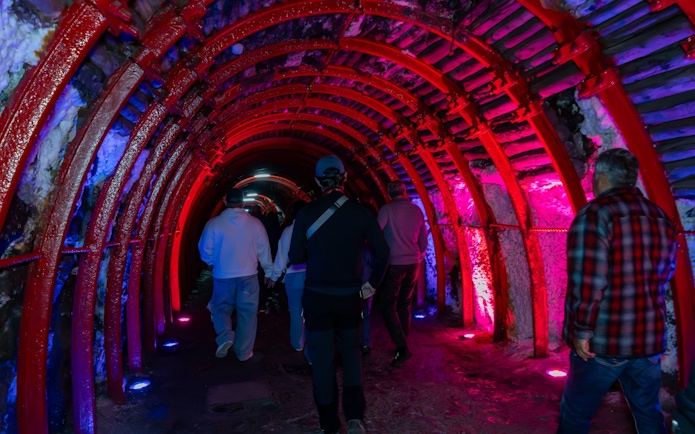 Tourists walking through illuminated tunnel to Zipaquira Salt Cathedral, Colombia.