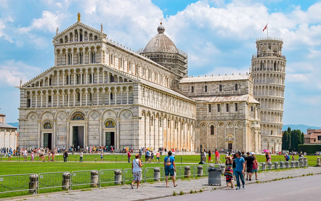 Cathedral and Leaning Tower of Pisa with tourists in the foreground.
