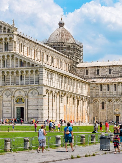 Cathedral and Leaning Tower of Pisa with tourists in the foreground.