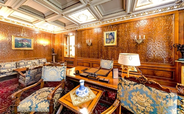 Interior of Ceaușescu Mansion in Bucharest with ornate wood paneling and vintage furniture.