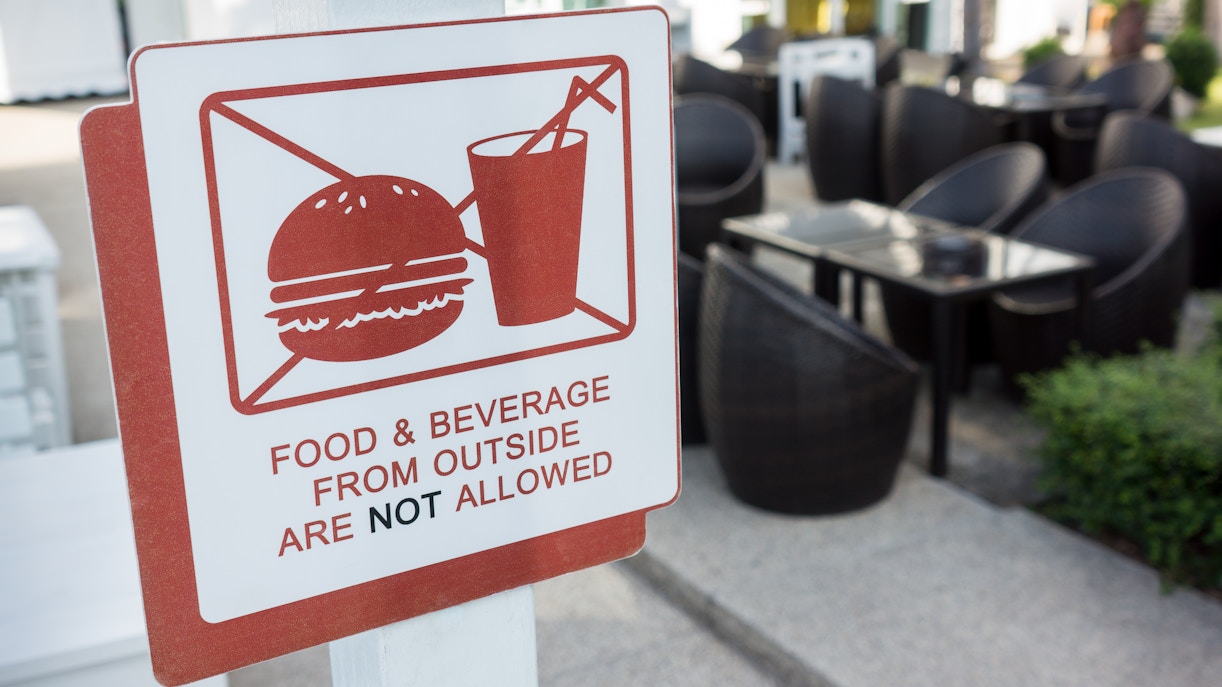 Eiffel Tower view with a sign indicating outside food not allowed in Paris, France.