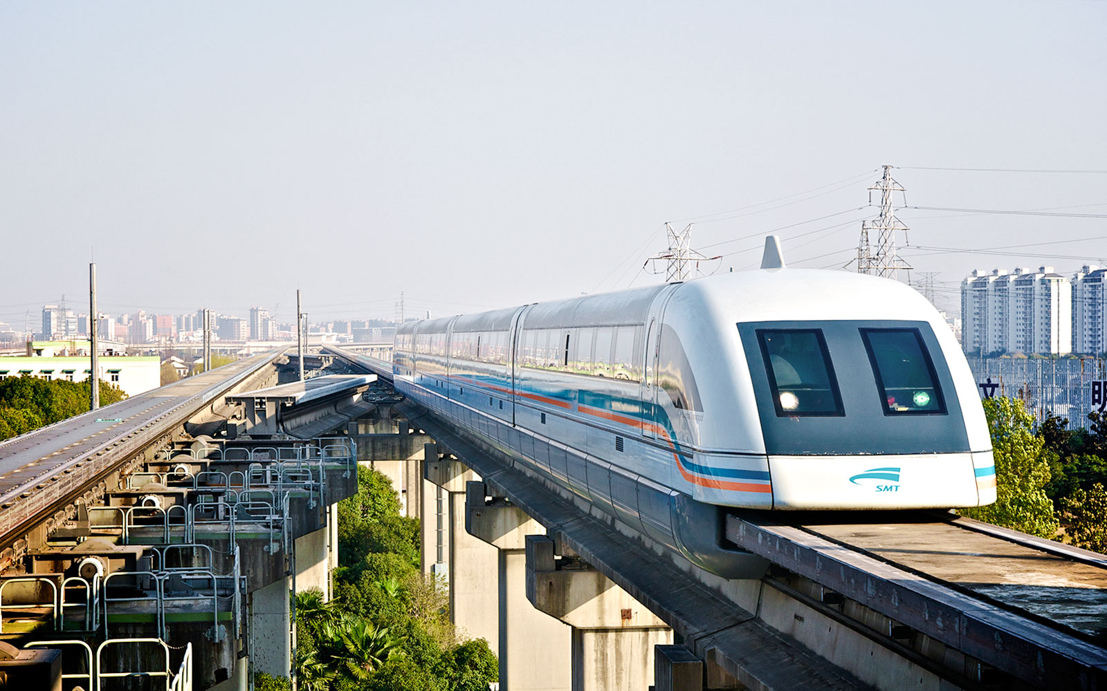 Shanghai Maglev Train on elevated track with city skyline in background.