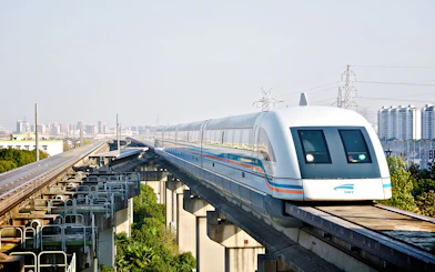 Shanghai Maglev Train on elevated track with city skyline in background.