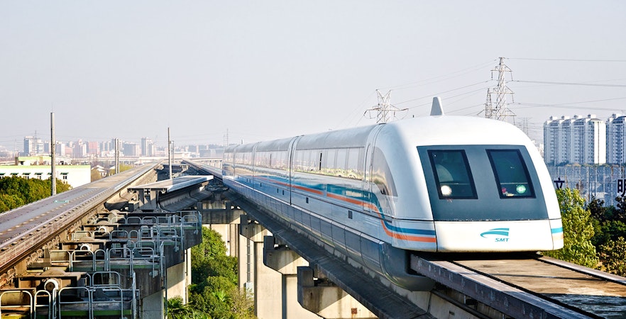 Shanghai Maglev Train on elevated track with city skyline in background.