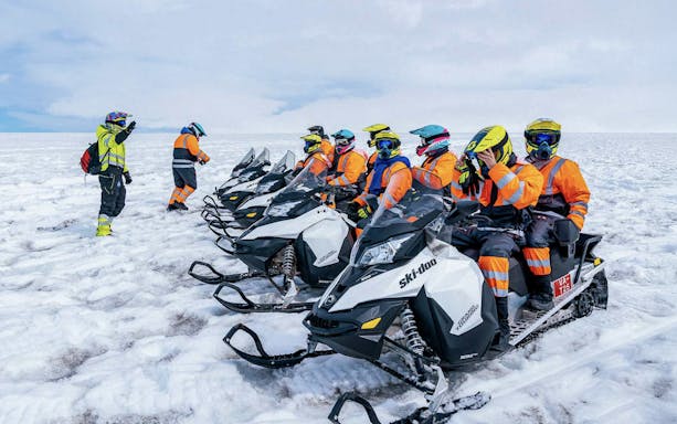 Snowmobile riders preparing for a tour on Langjökull glacier.