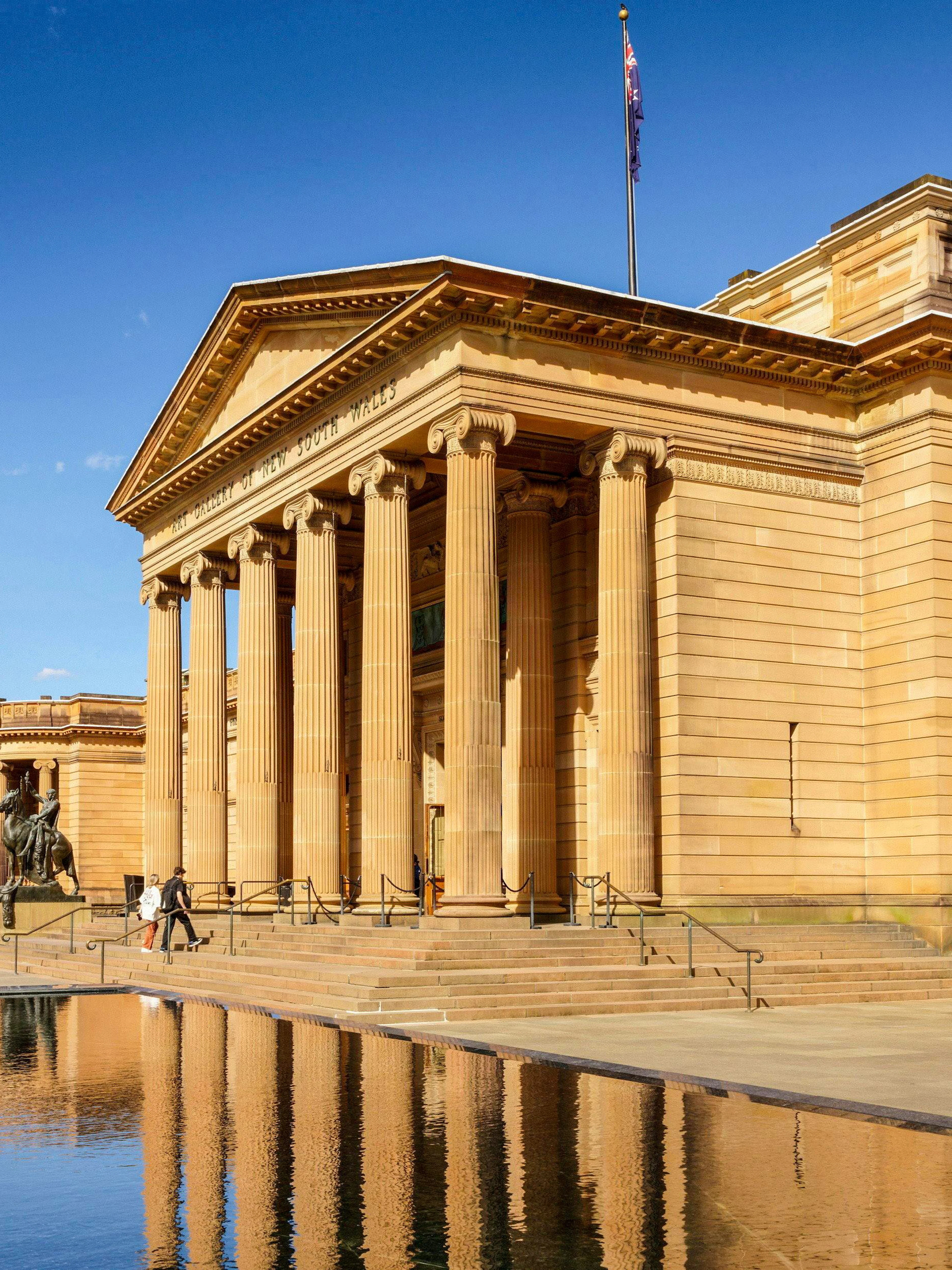 Naala Nura building with classical columns and reflecting pool in front.