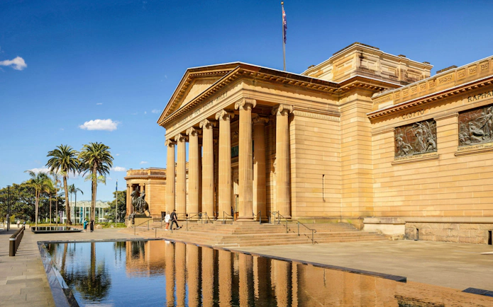 Naala Nura building with classical columns and reflecting pool in front.