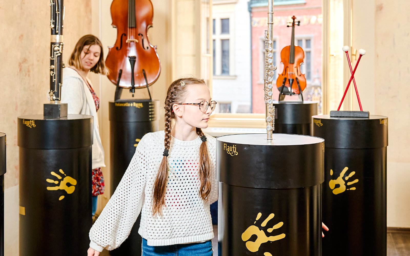 Guests interacting with musical exhibits at Mozart Interactive Museum in Prague.