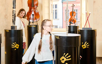 Guests interacting with musical exhibits at Mozart Interactive Museum in Prague.