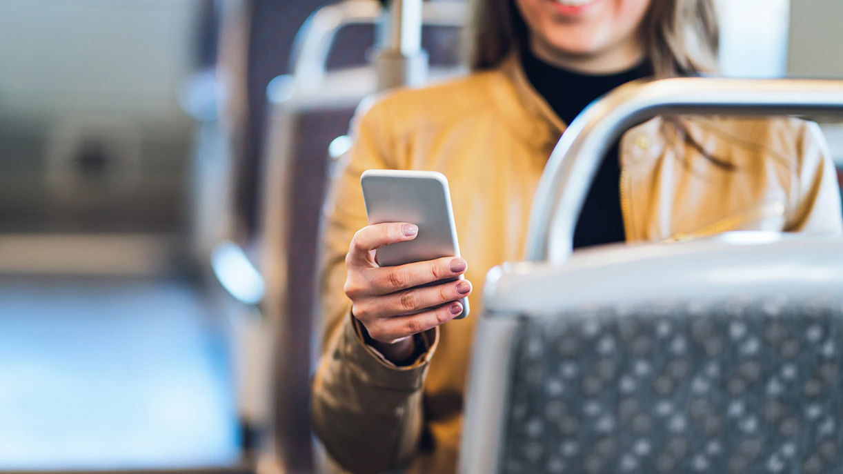 Traveler using smartphone on bus wifi.