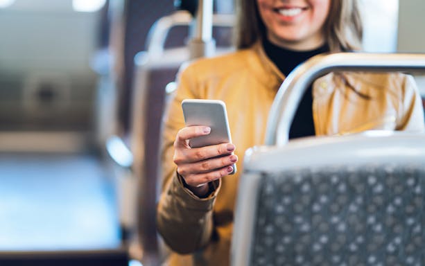 Traveler using smartphone on bus wifi.