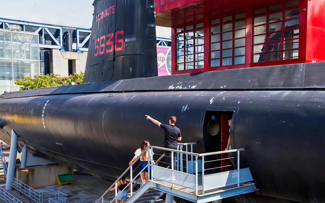 Visitors exploring a submarine exhibit at Cité des Sciences et de l'Industrie, Paris.