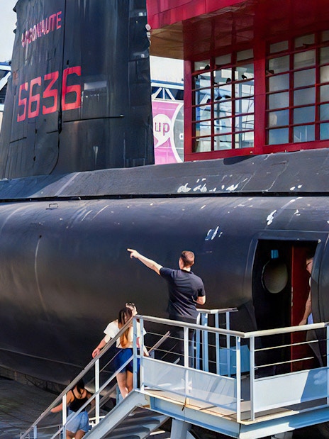 Visitors exploring a submarine exhibit at Cité des Sciences et de l'Industrie, Paris.