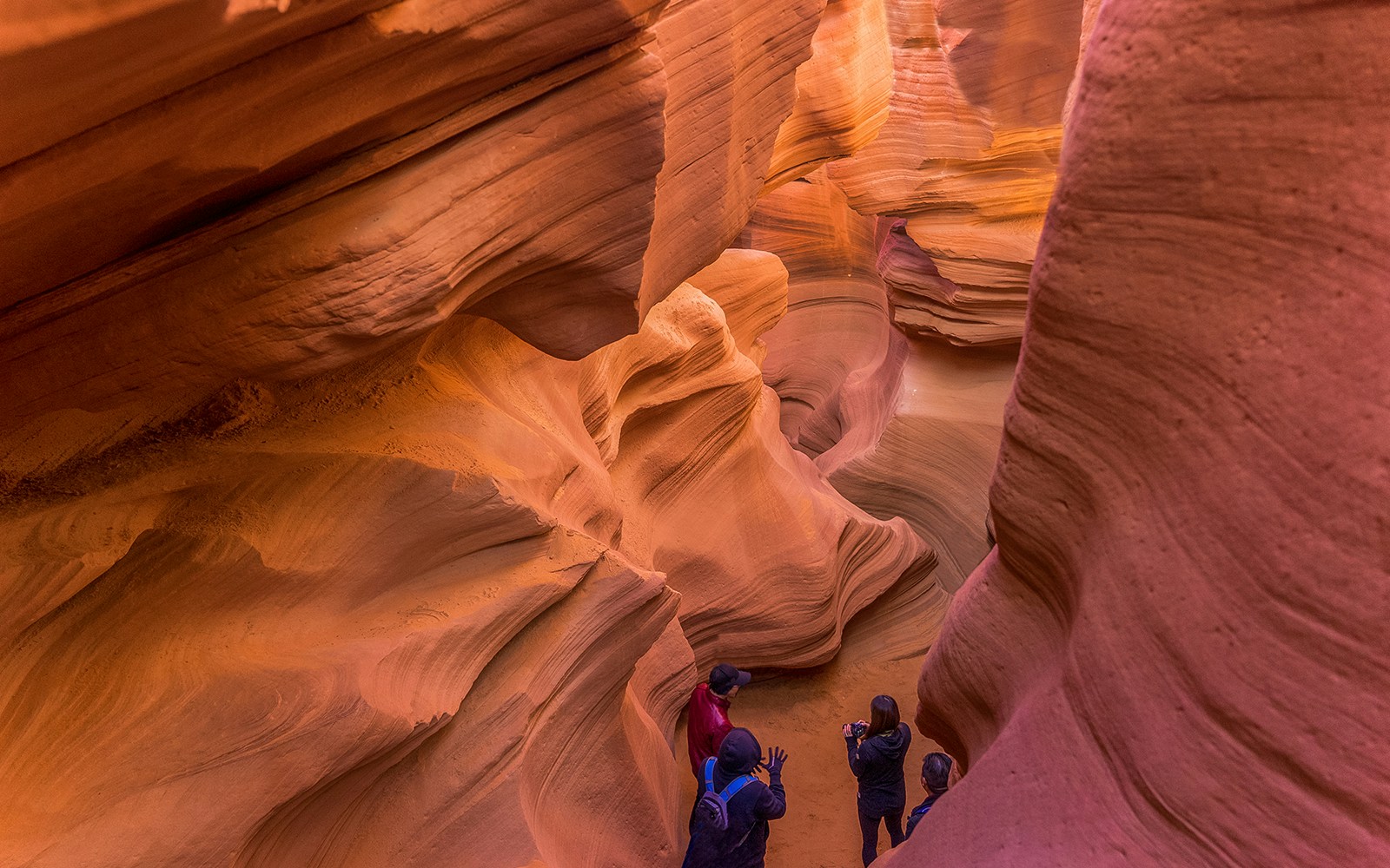 Tourists exploring the vibrant, narrow pathways of Lower Antelope Canyon