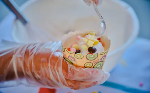 Decorating a cupcake with colorful toppings at a birthday party in Phuket.