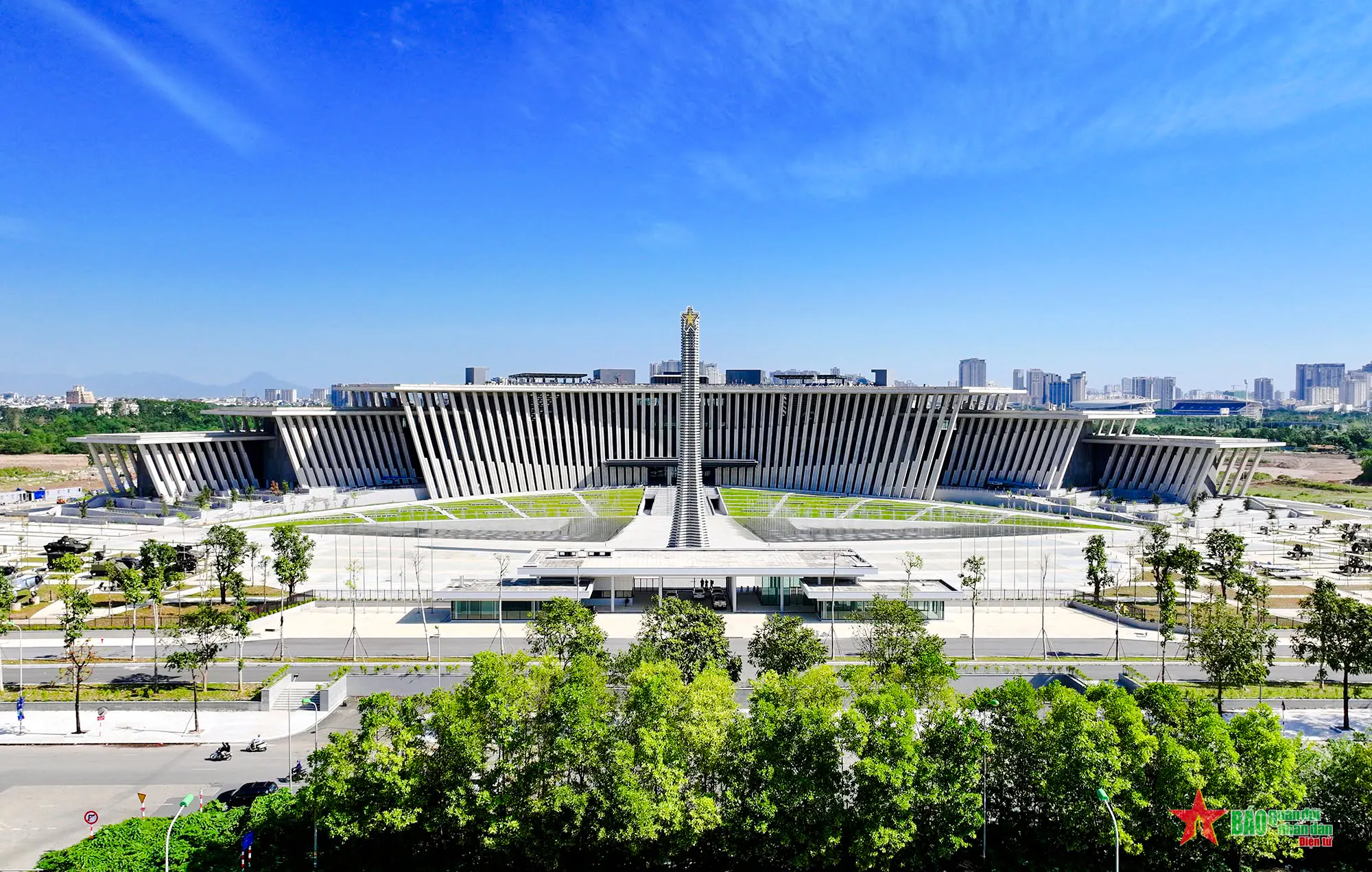 Vietnam Military History Museum building in Hanoi with city skyline in the background.