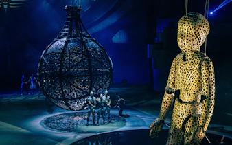 Puppet in leopard print near Globe of Death at La Perle performance.