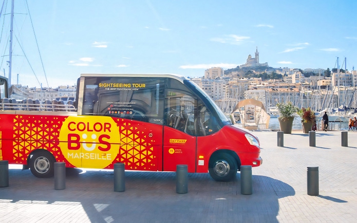 Colorbus Marseille at port with Notre-Dame de la Garde in background.