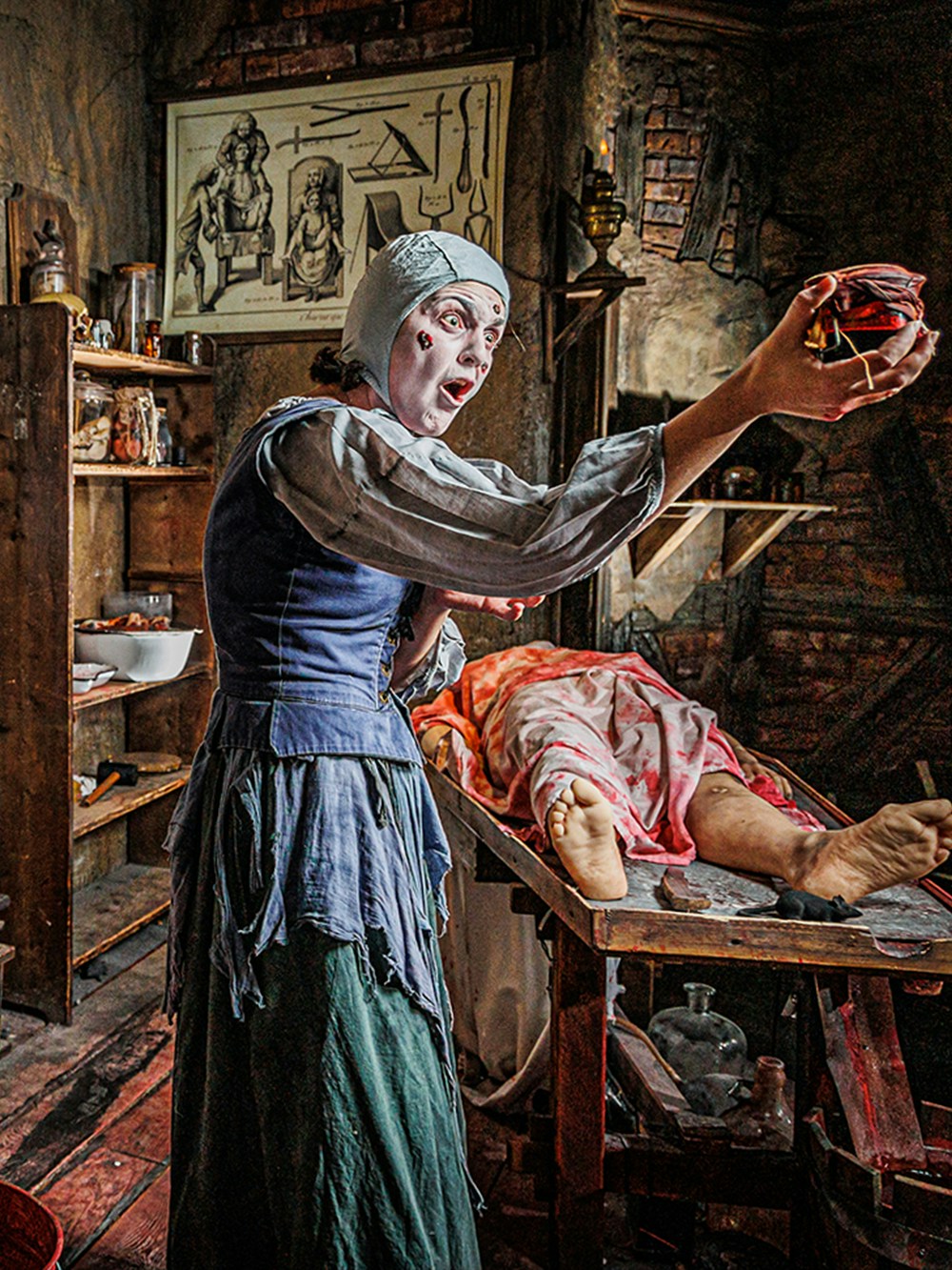 Man in medieval torture chamber with tools at London Dungeon.